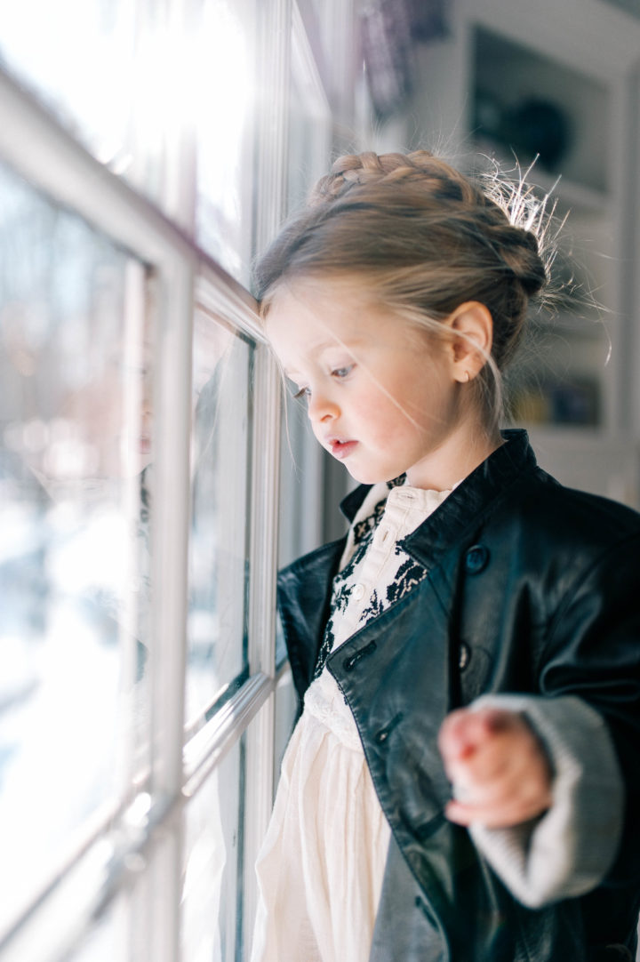 Marlowe Mae Martino looks out the window of her Connecticut home wearing a halo braid.