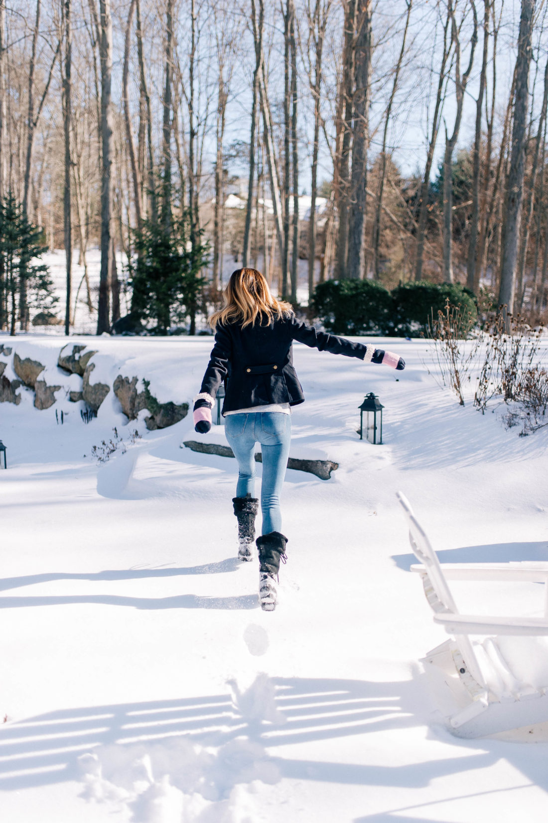 Eva Amurri Martino jumps through the snow outside her Connecticut home while wearing black furry snow boots