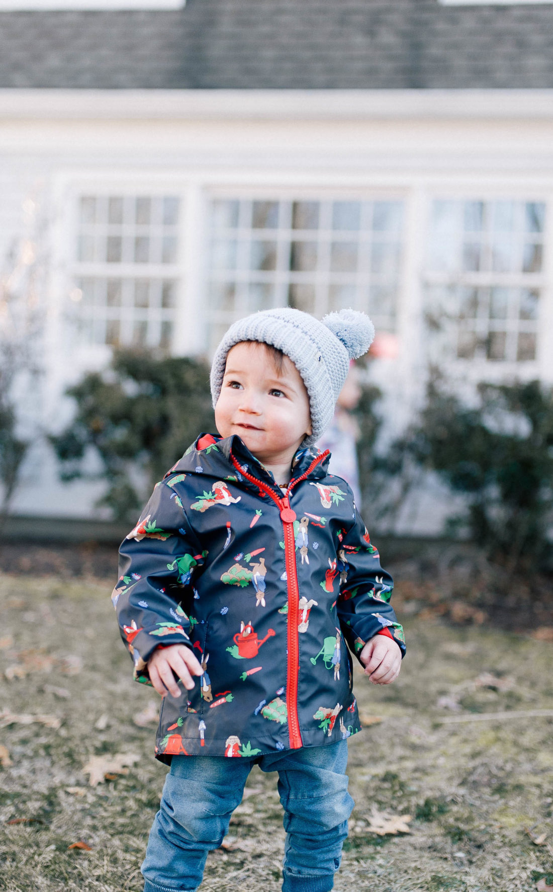 Major Martino wears a Peter Rabbit rain coat and a pom pom knit hat while he plays outside him home