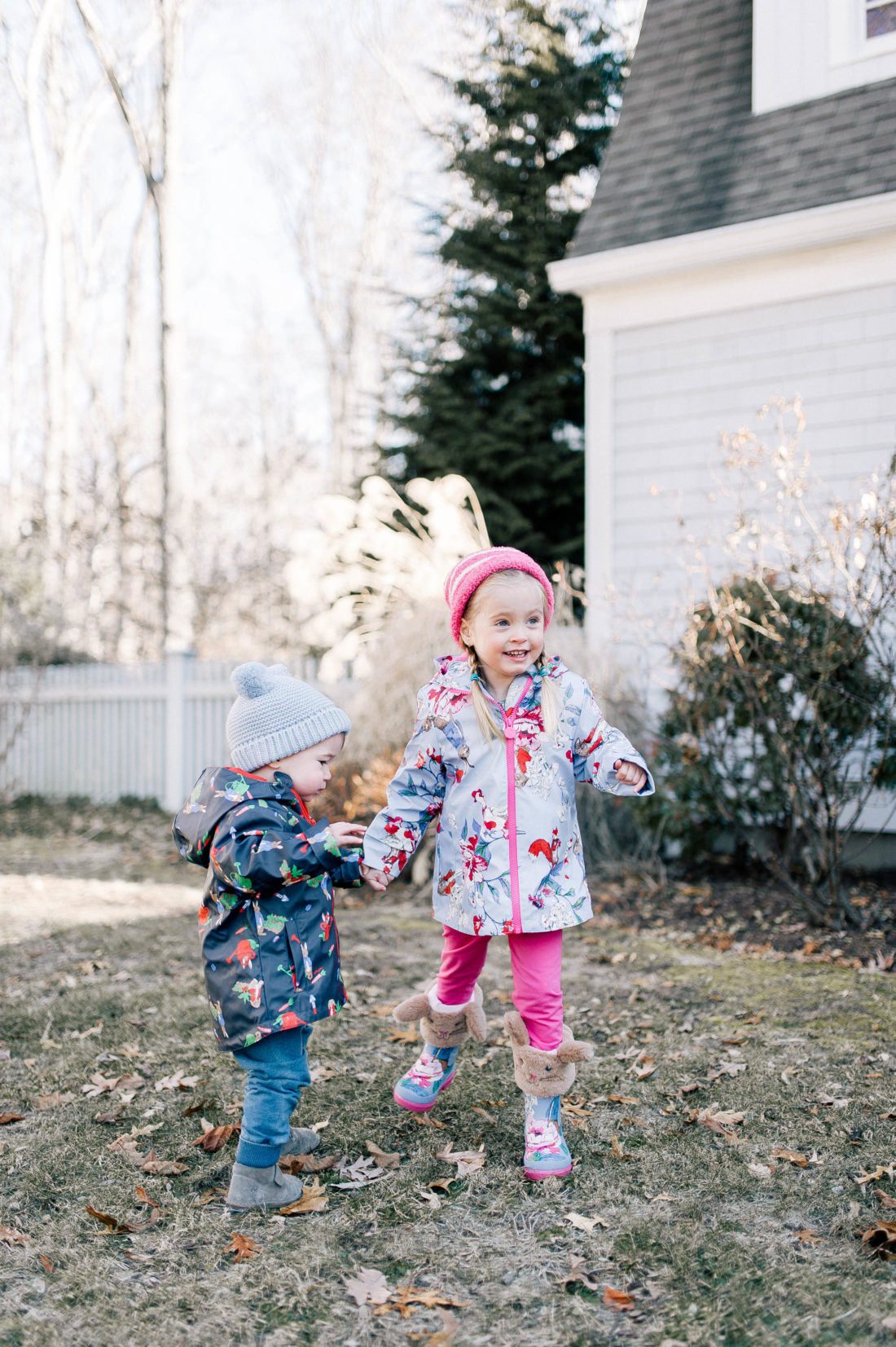 Marlowe and Major Martino play in the garden of their Connecticut home wearing rain coats and boots