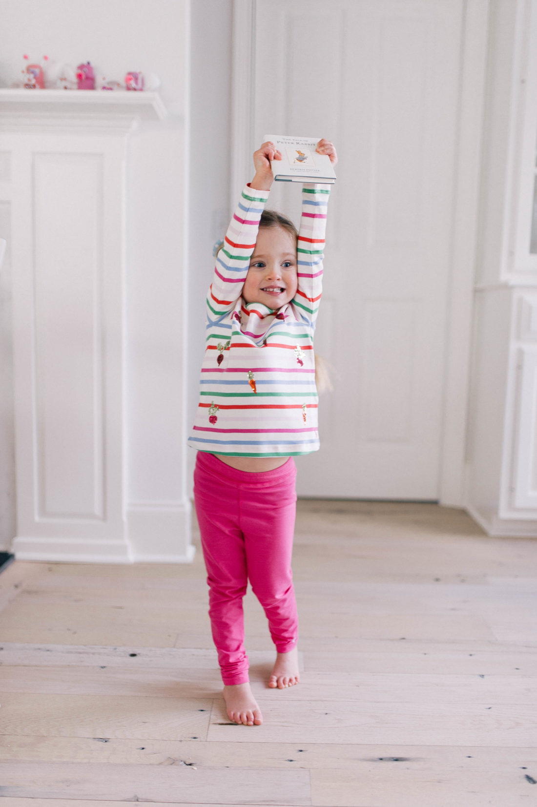 Marlowe Martino wears a striped shirt and holds the Peter Rabbit book