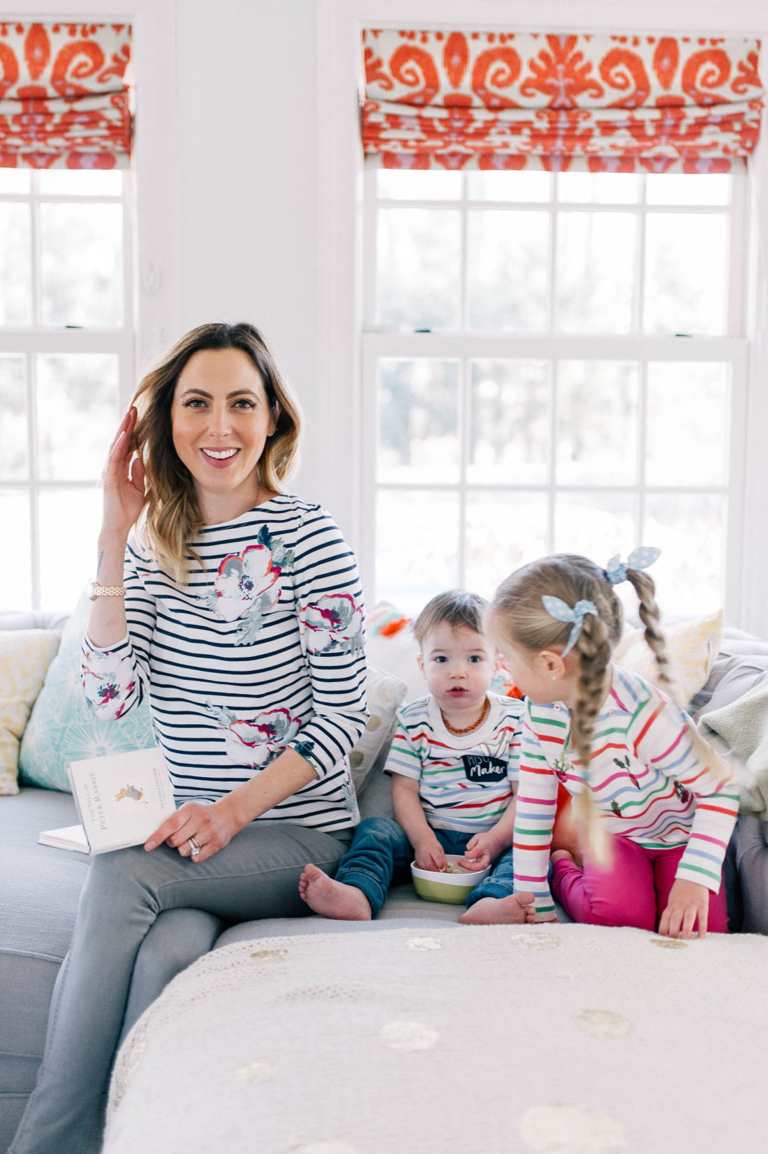 Eva Amurri Martino wears stripes and reads the Peter RAbbit book to her children on the couch at home in Connecticut