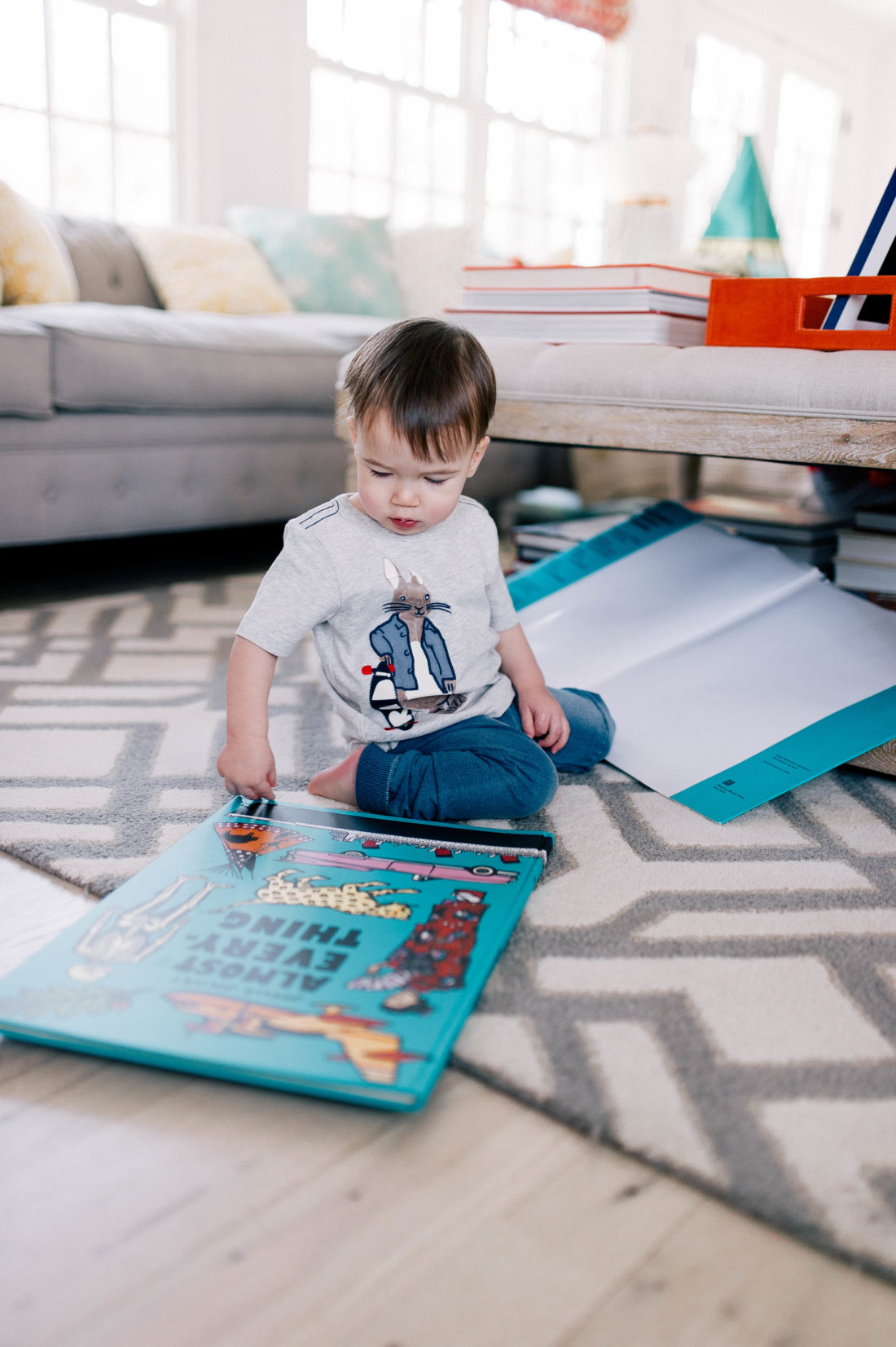 Major Martino wears a Peter Rabbit tee shirt and reads books on the floor of the family room