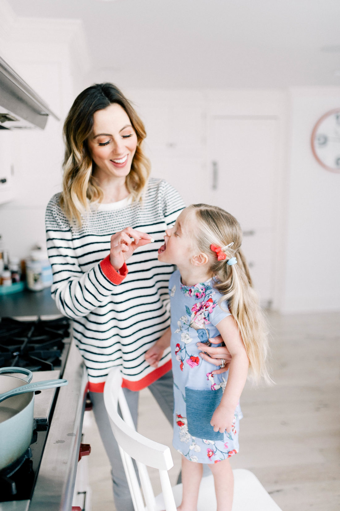 Eva Amurri Martino feeds daughter Marlowe a white chocolate chip while cooking in the kitchen at home