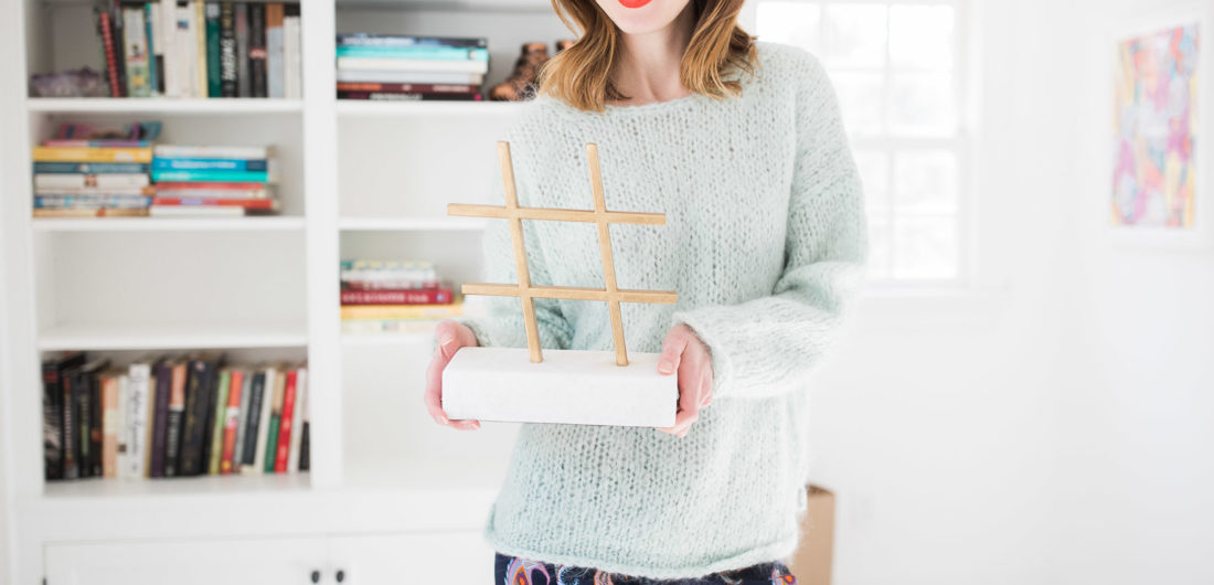 Eva Amurri Martino holds a marble and brass hashtag object in the studio of her Connecticut home