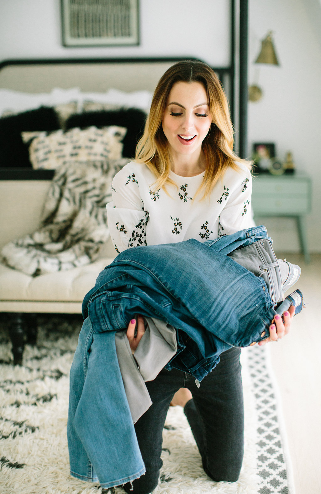 Eva Amurri Martino holds a large pile of jeans as she cleans out her closet for Spring