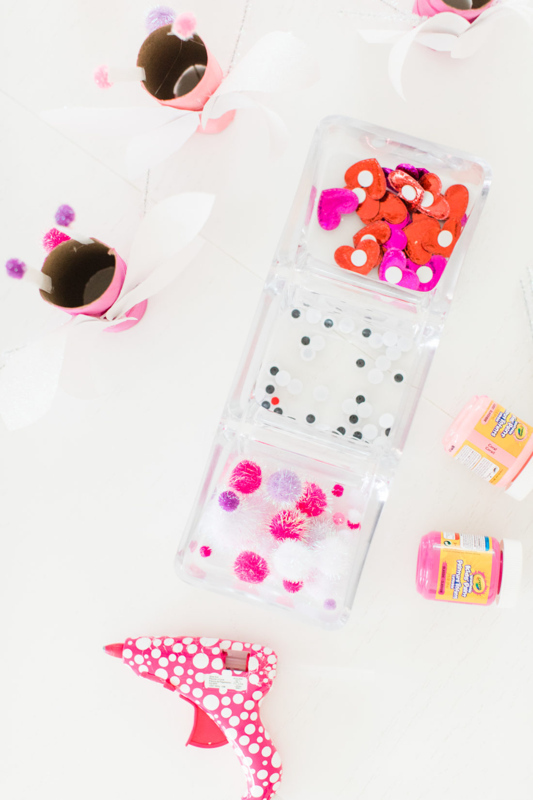 Pink, white, red, and sparkly materials to create DIY lovebugs