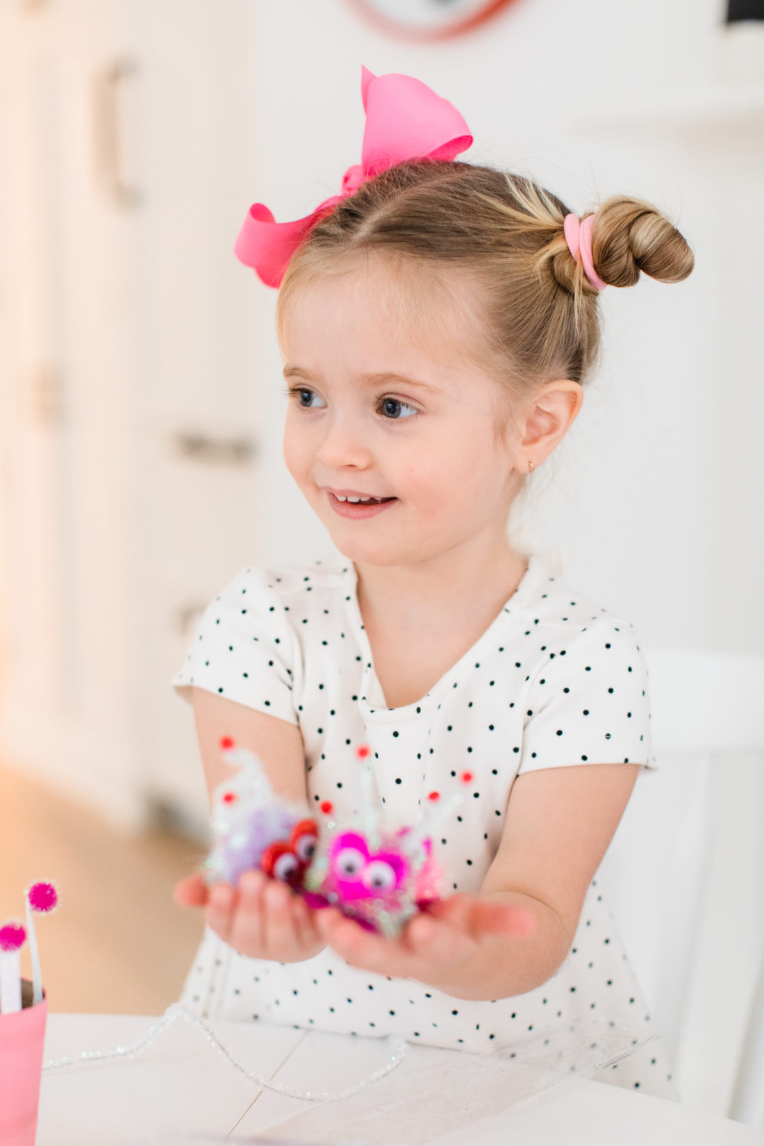 Marlowe Martino holds some cute DIY pompom Lovebugs