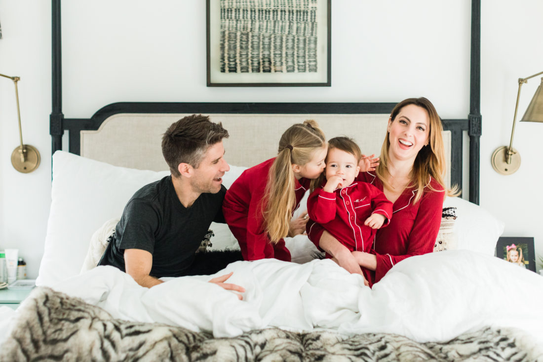 Eva Amurri martino, Kyle Martino, and children Marlowe and Major Martino cuddle in bed wearing red pajamas for Valentine's Day in the master bedroom of their Connecticut home