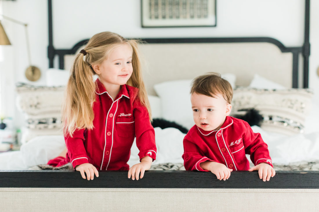 Marlowe and Major Martino kneel at the foot of their parents' bed wearing matching red pajamas for Valentine's Day