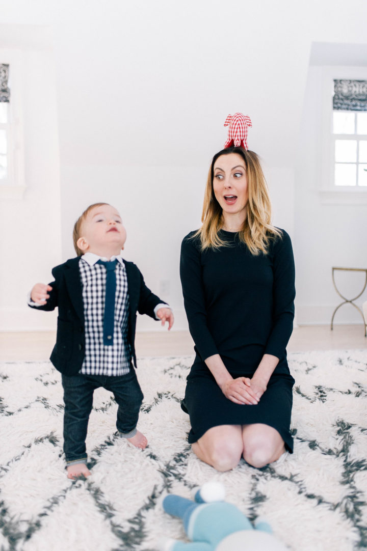 Eva Amurri Martino plays on the rug in her bedroom with son Major James Martino, who is wearing a navy blue blazer, gingham shirt, blue tie and jeans.