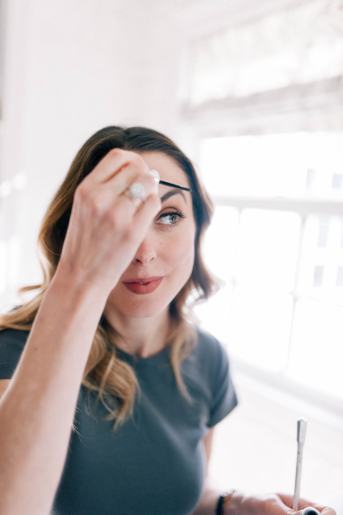 Eva Amurri Martino sits in front of the vanity in the Glam Room at her Connecticut home and fills in her eyebrows