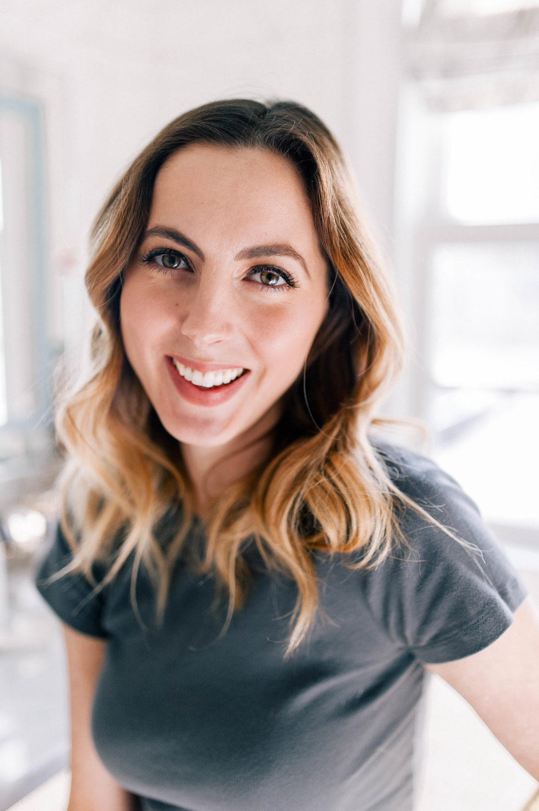 Eva Amurri Martino smiles in her glam room wearing a grey tshirt, as she shows the final progression of how she grew in her eyebrows and grooms them to achieve her best look