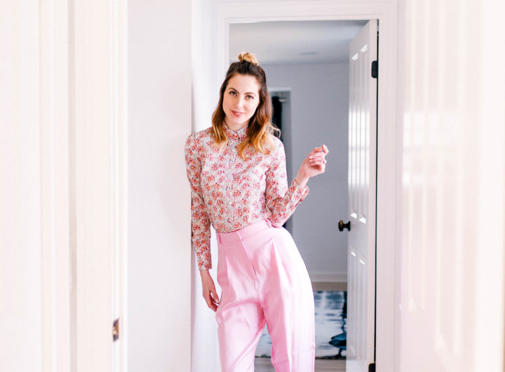 Eva Amurri Martino wears the hottest spring fashion trends: wide pink trousers, a pink floral button up shirt, and her hair in a half up half down topknot in her Connecticut home.