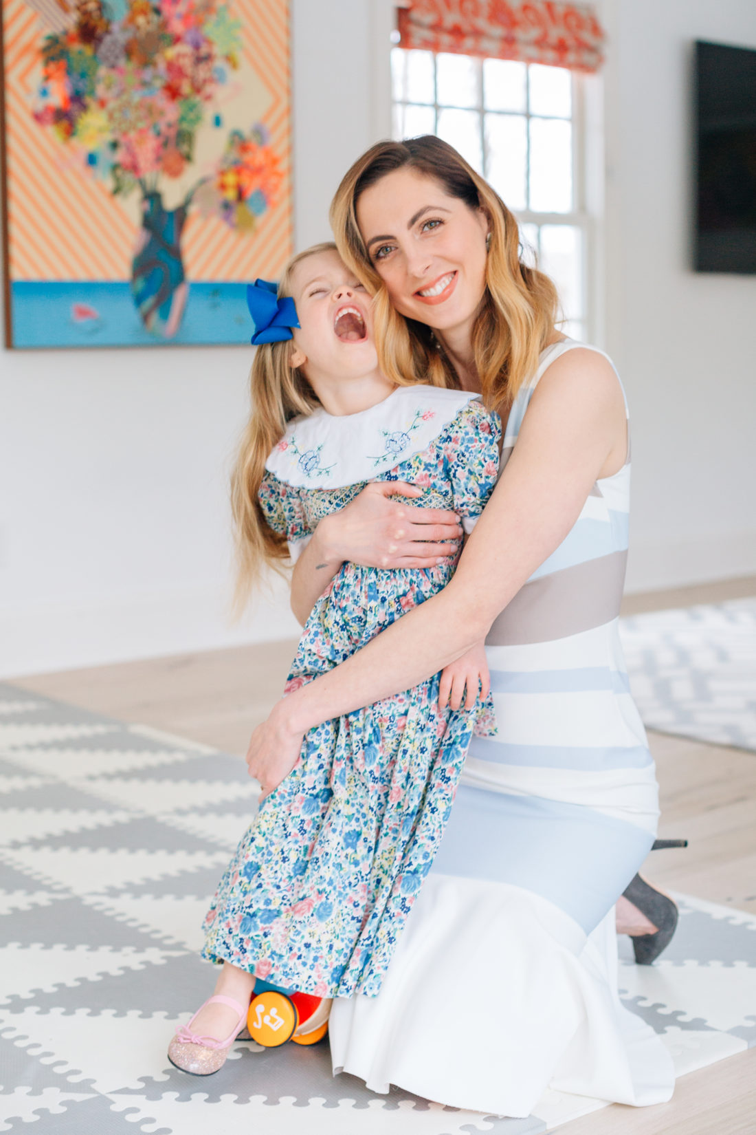 Eva Amurri Martino holds three year old daughter Marlowe Martino on her lap wearing a floral dress for Easter