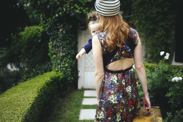 Eva Amurri Martino carrying her daughter Marlowe in a carrier with a suitcase ready to travel