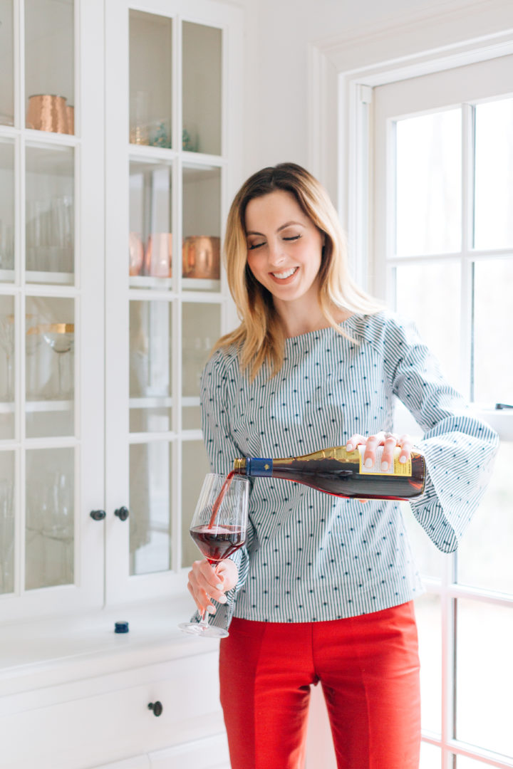 Eva Amurri Martino pours a glass of red wine in a blue at her Connecticut home