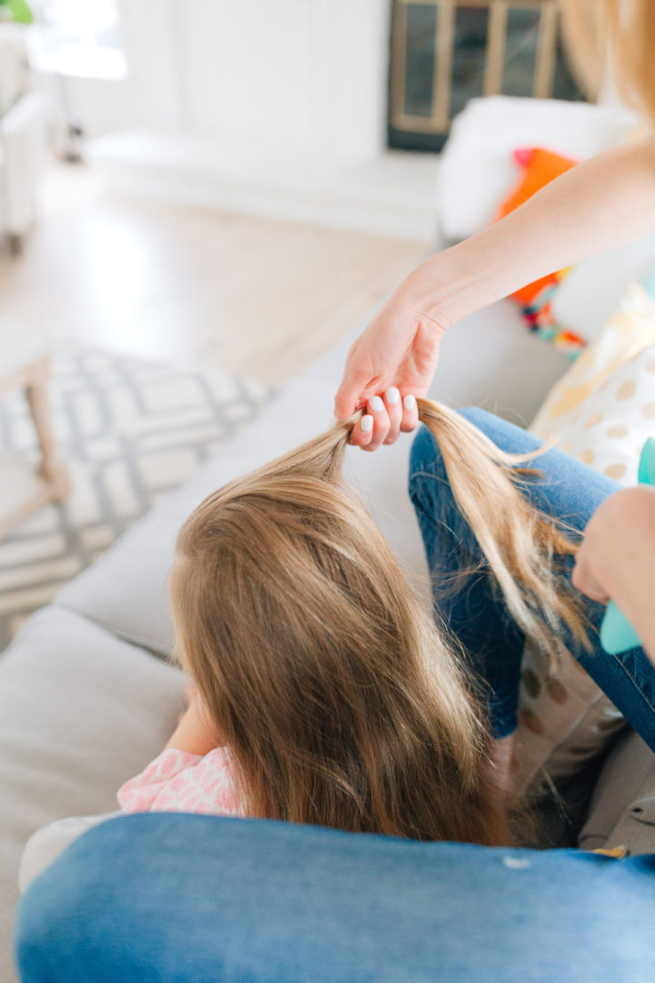 Eva Amurri Martino styles her daughter Marlowe's hair while she sits on the couch.