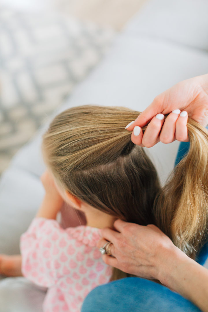 Eva Amurri Martino styles her daughter Marlowe's hair while she sits on the couch.