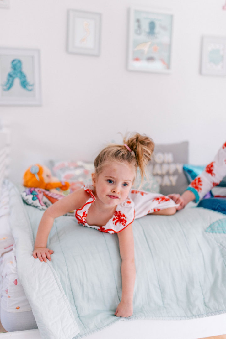 Eva Amurri Martino's daughter Marlowe lies on her bed in a topknot a bright dress