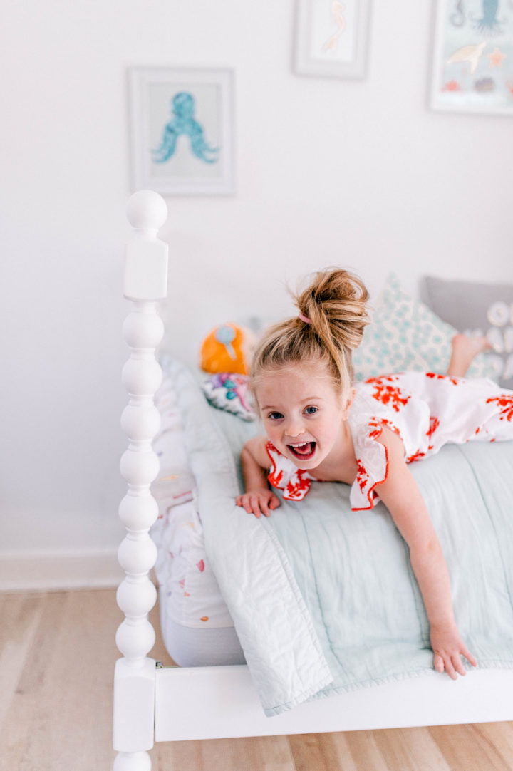 Eva Amurri Martino's daughter Marlowe lies on her bed in a topknot a bright dress