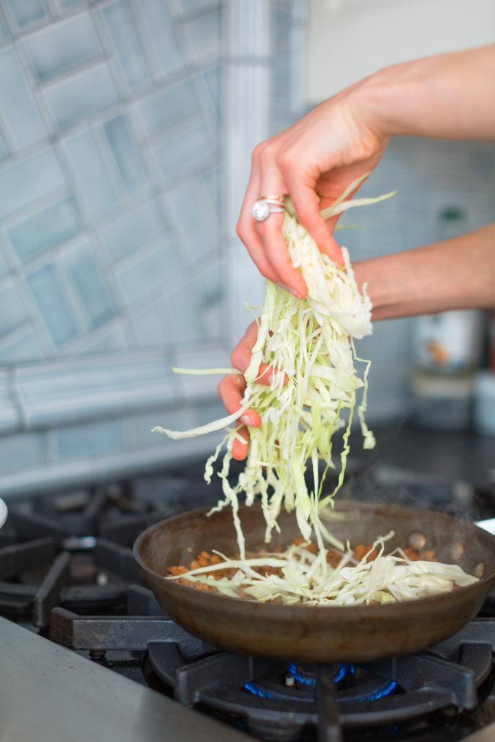 Eva Amurri Martino shreds lettuce in a skillet.