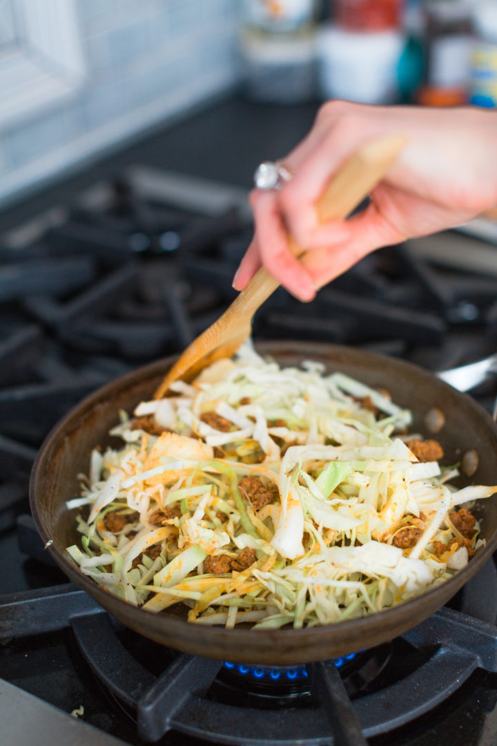 Eva Amurri Martino stirs lettuce in a skillet.