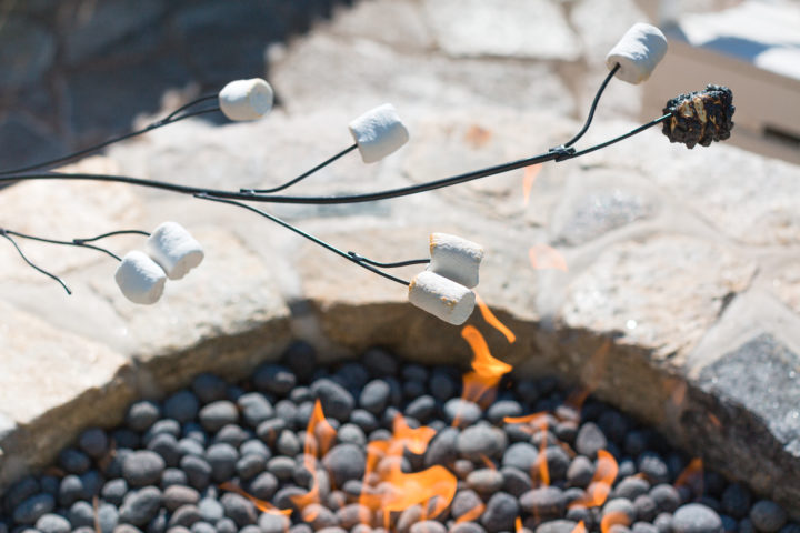roasts marshmallows in a colorful frock at her Connecticut home