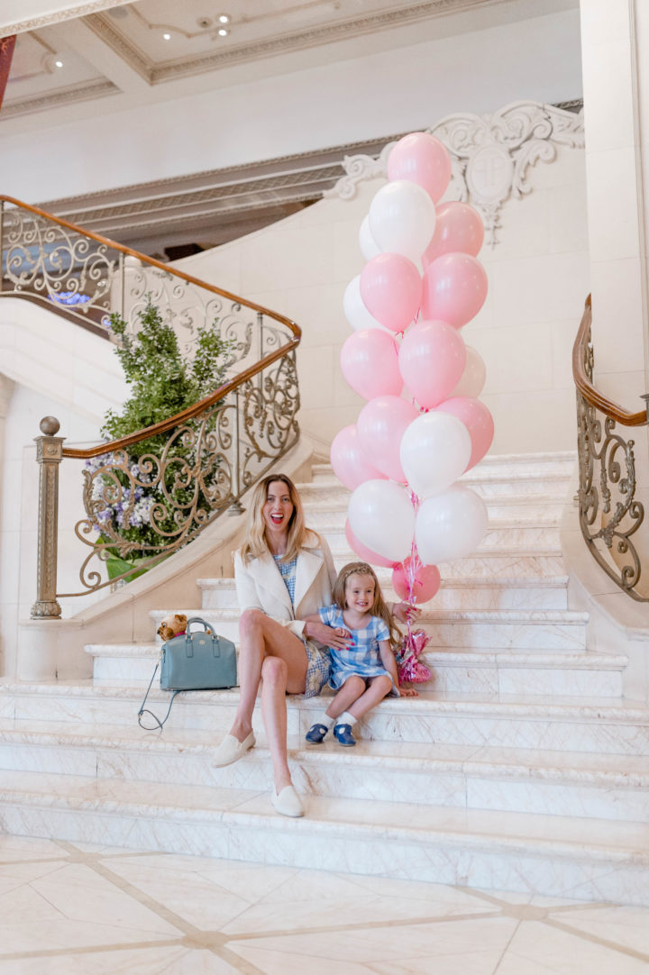 Eva Amurri poses with her daughter Marlowe on marble steps with pink and white balloons at the Plaza Hotel in New York City