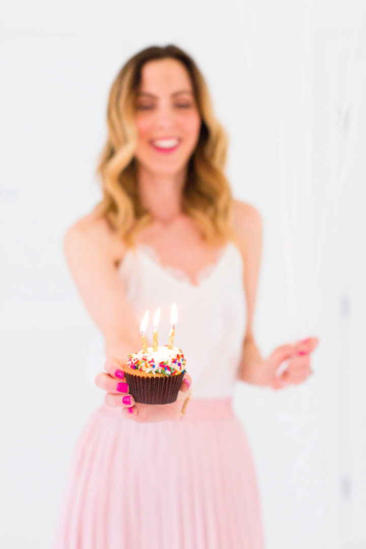 Eva Amurri Martino holds a cupcake with a candle to commemorate the 3rd birthday of her blog Happily Eva After
