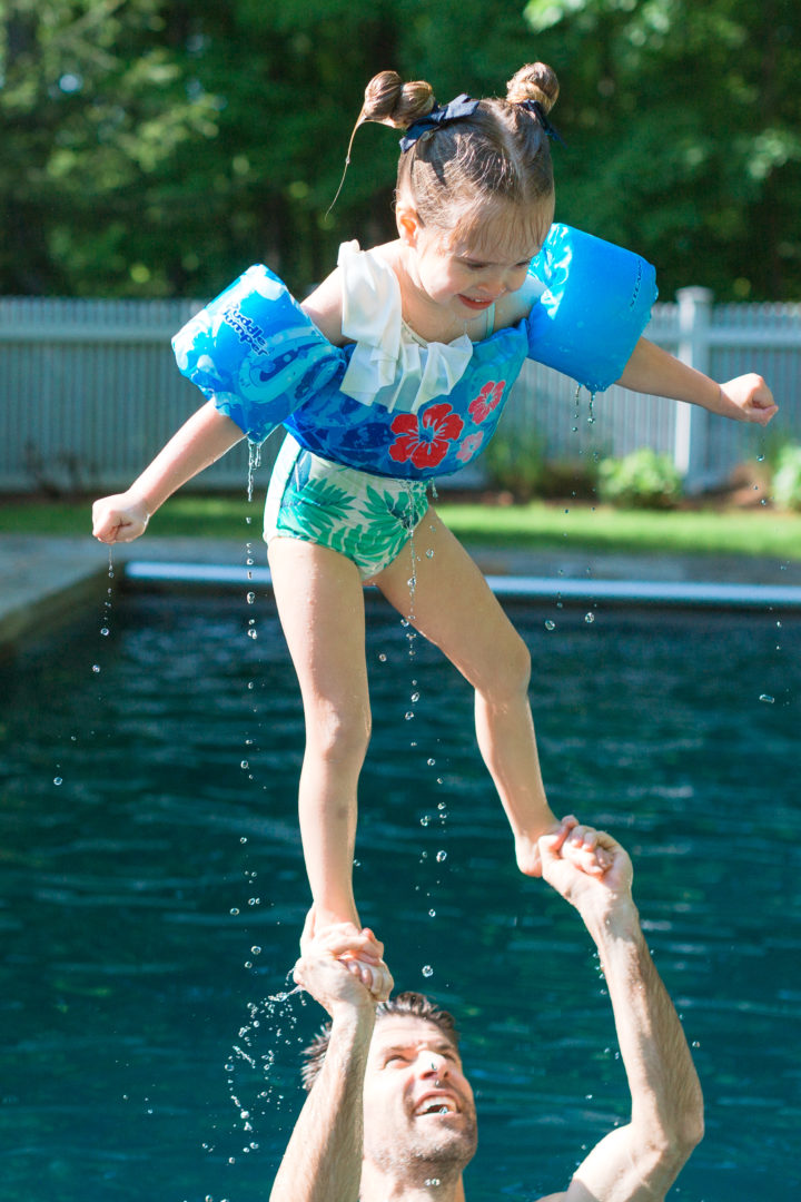 Kyle Martino lifts his daughter Marlowe over his head in the pool at their Connecticut home