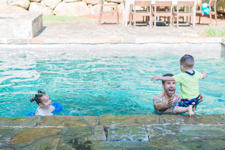 Kyle Martino helping his son Major into the pool at their house in Connecticut.