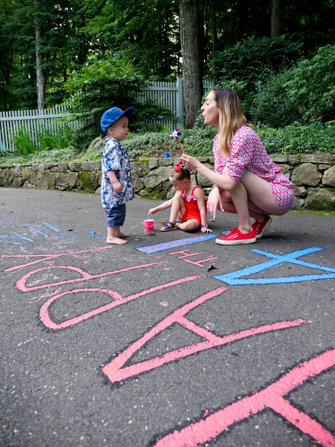 Eva Amurri Martino wears a red white and blue romper, and blows on a pinwheel on the fourth of july at home in Connecticut