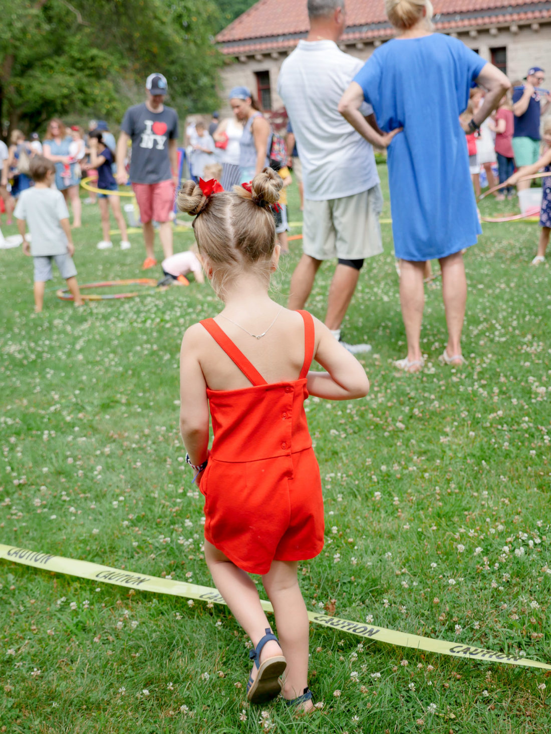 Marlowe Martino wears a red romper and explores a fourth of july lawn party