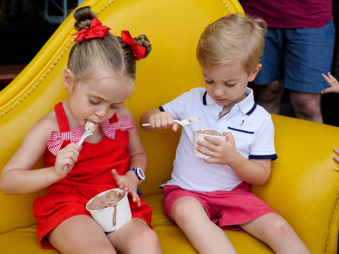 Marlowe Martino wears a red romper and eats ice cream with a friend on the fourth of july