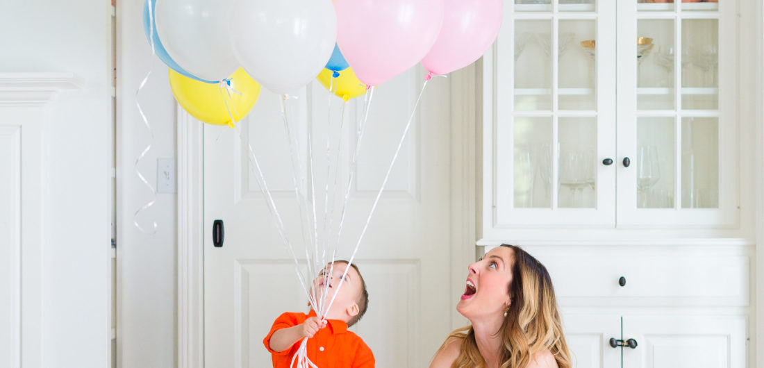 Eva Amurri Martino plays with her son Major while holding a handful of colorful balloons