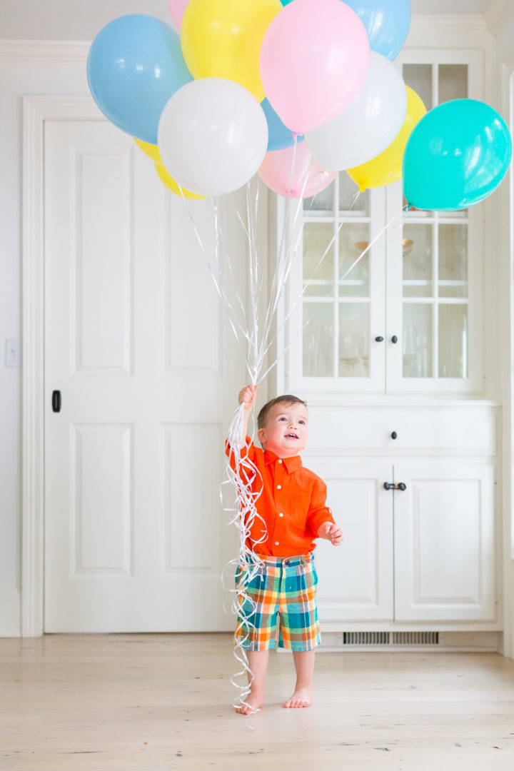 Eva Amurri Martino's son Major wears a colorful outfit while holding a handful of multicolored balloons in their Connecticut home.