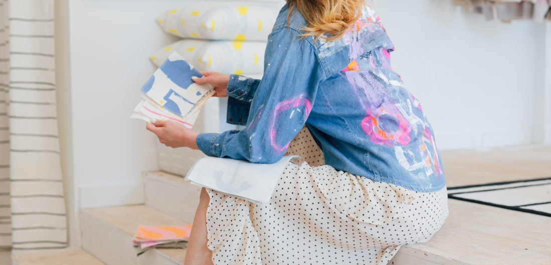 Eva Amurri Martino wears a painted Kerri Rosenthal denim jacket and peruses fabric and wallpaper samples for her home renovation