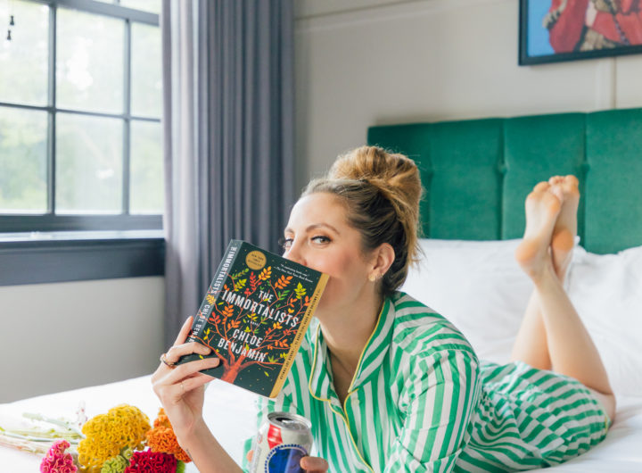 Eva Amurri Martino lays in bed reading her newest book club pick: The Immortalists by Chloe Benjamin