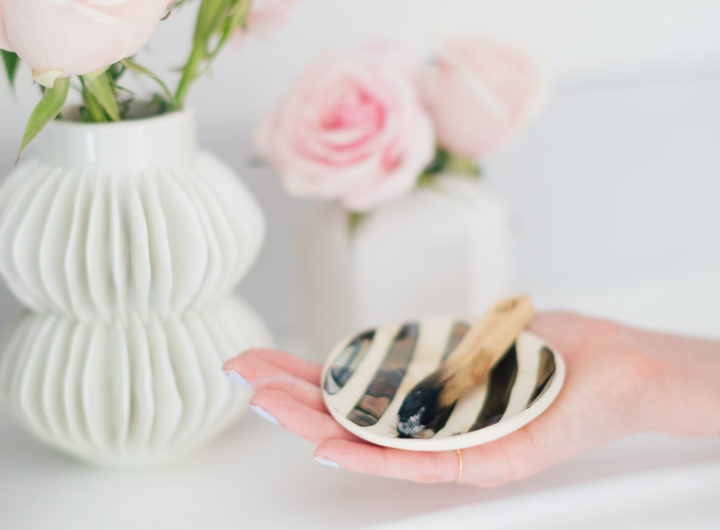 Eva Amurri Martino holding a smudge bowl with sage, and a piece of palo santo wood to cleanse the energy in her Westport CT home