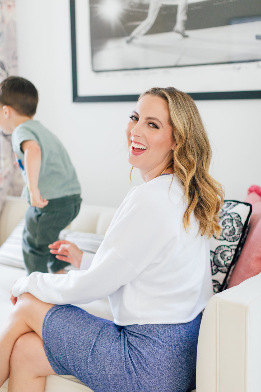 Eva Amurri Martino smiles in a rainbow sweatshirt showing off her easy pretty curls