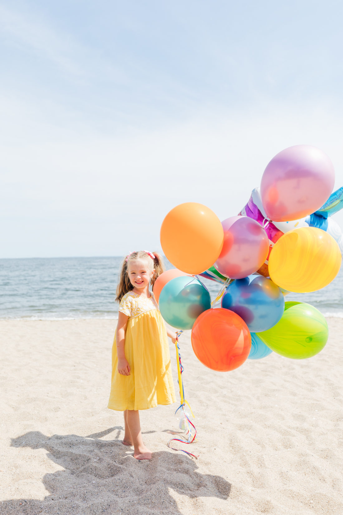 Marlowe Martino holds balloons on the beach in Connecticut to commemorate her 5th birthday