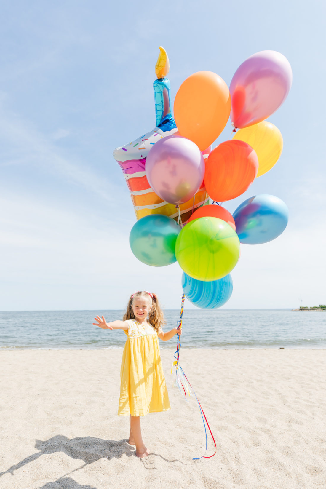 Marlowe Martino holds balloons on the beach in Connecticut to commemorate her 5th birthday