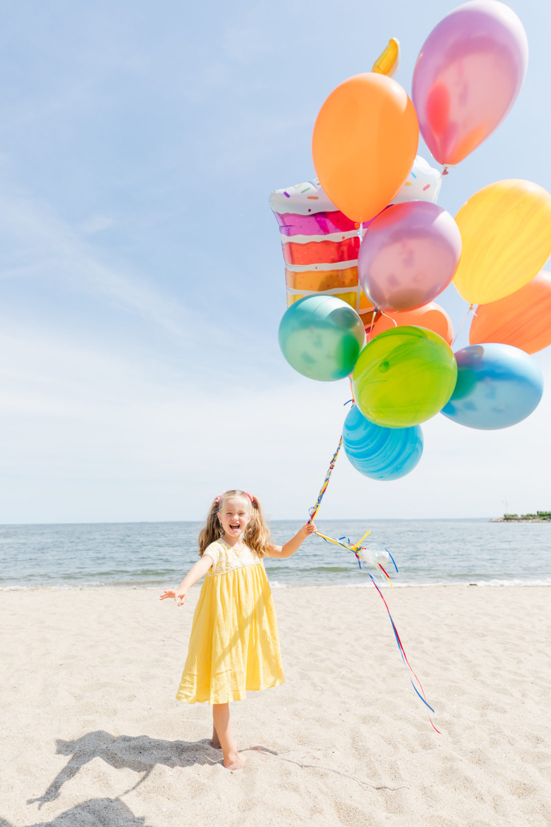 Marlowe Martino holds balloons on the beach in Connecticut to commemorate her 5th birthday