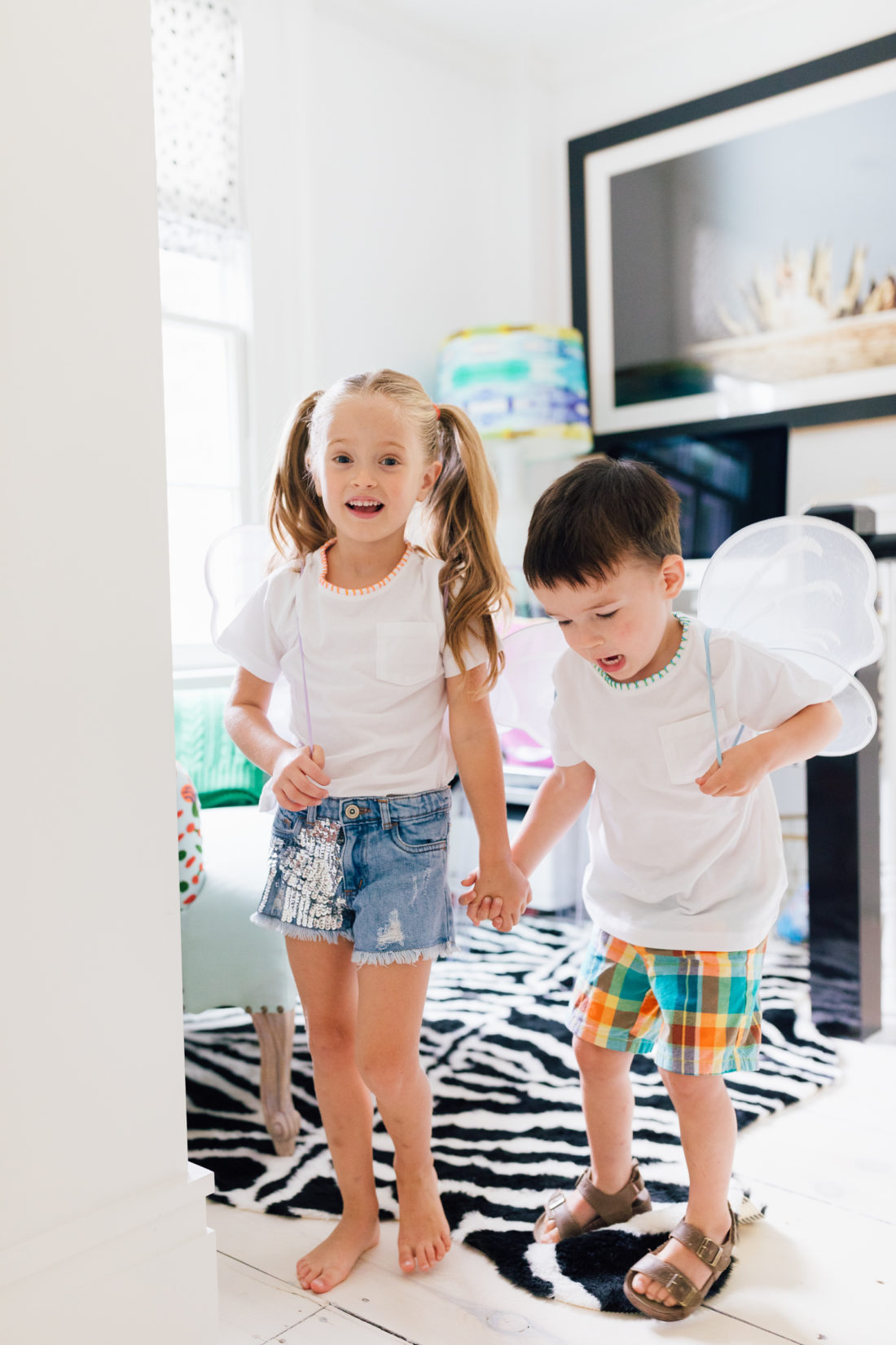 Marlowe and Major Martino holding hands in their embroider tees made by mom Eva Amurri Martino