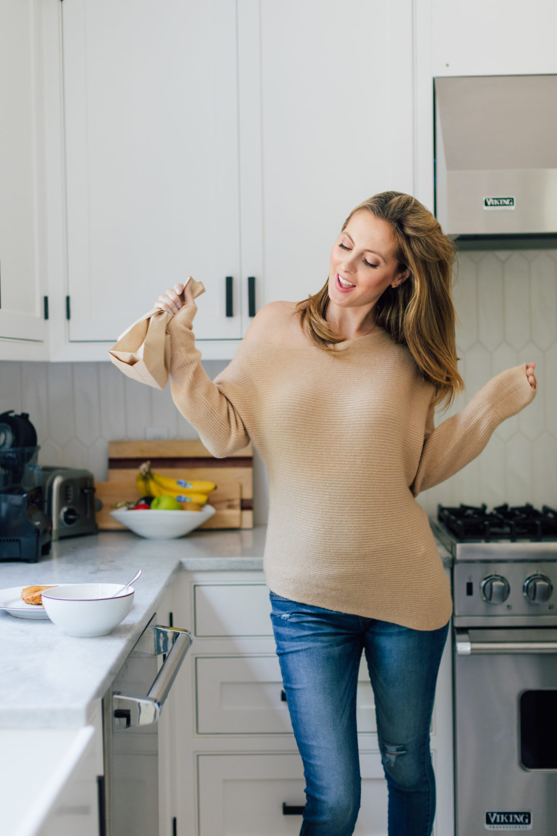 Eva Amurri Martino shakes up her baked apple cider donuts in a brown bag with sugar