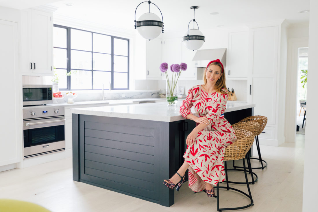 Eva Amurri Martino wears a red and white dress, and sits on a bar stool in the renovated kitchen in her Connecticut home