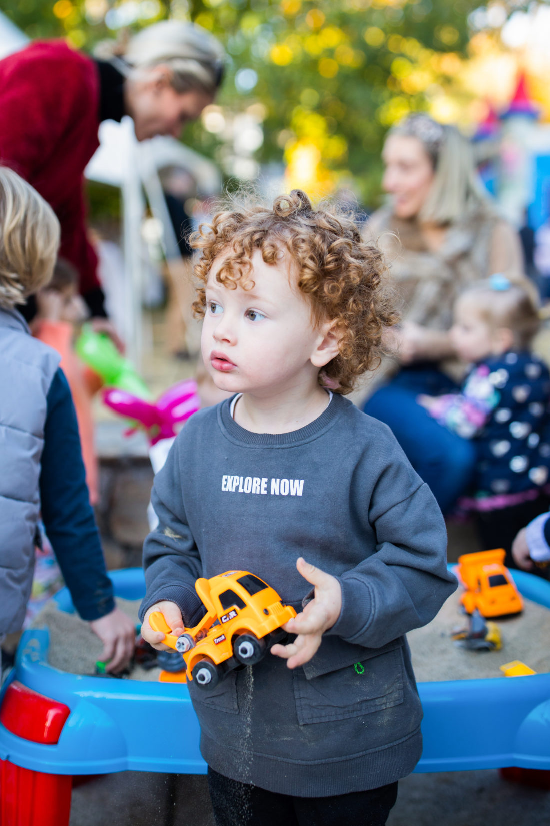 A partygoer playing with a construction truck toy at Major Martino's Construction Zone themed birthday party