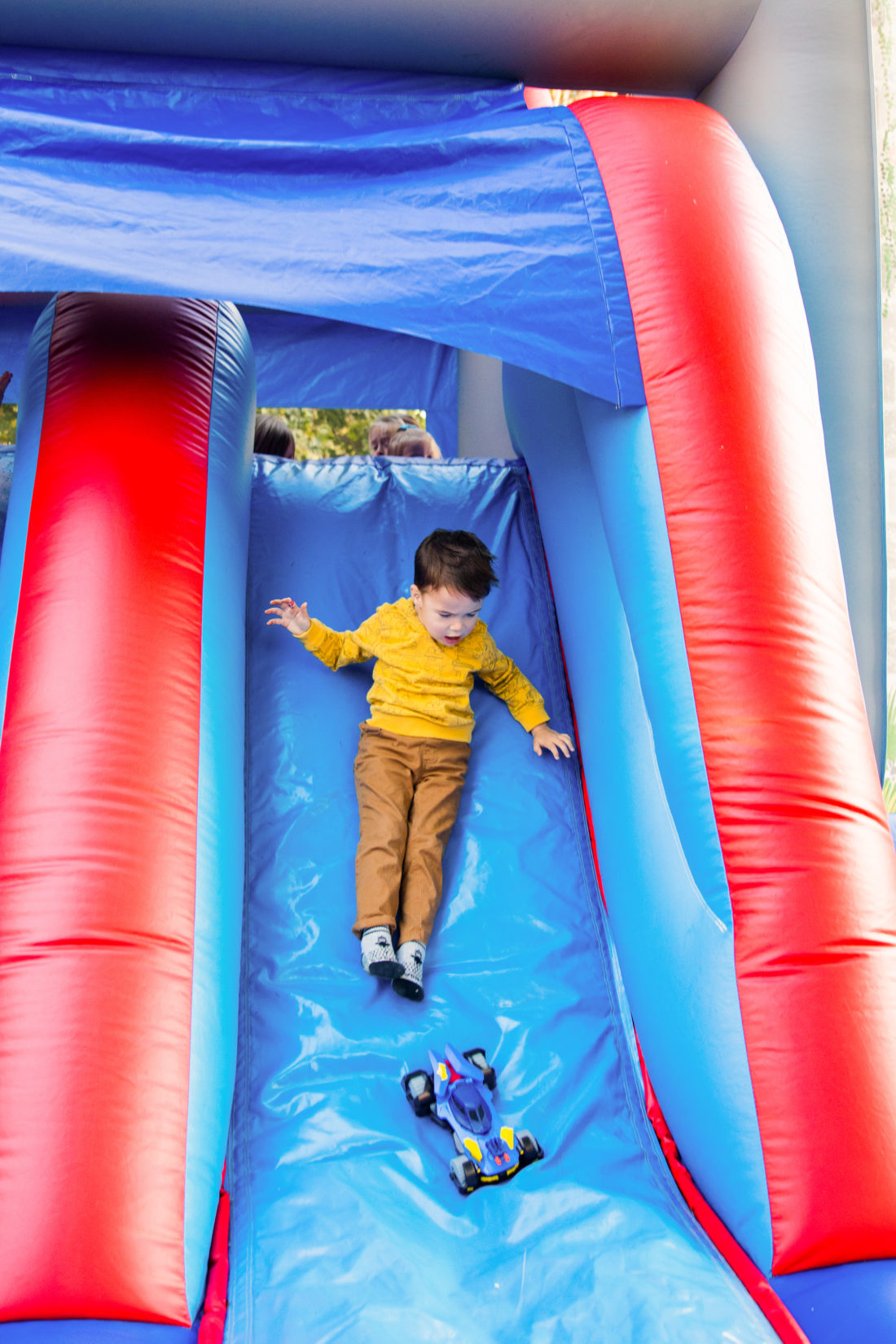 Major Martino slides down the side of the Bounce House at his Construction Zone themed birthday party