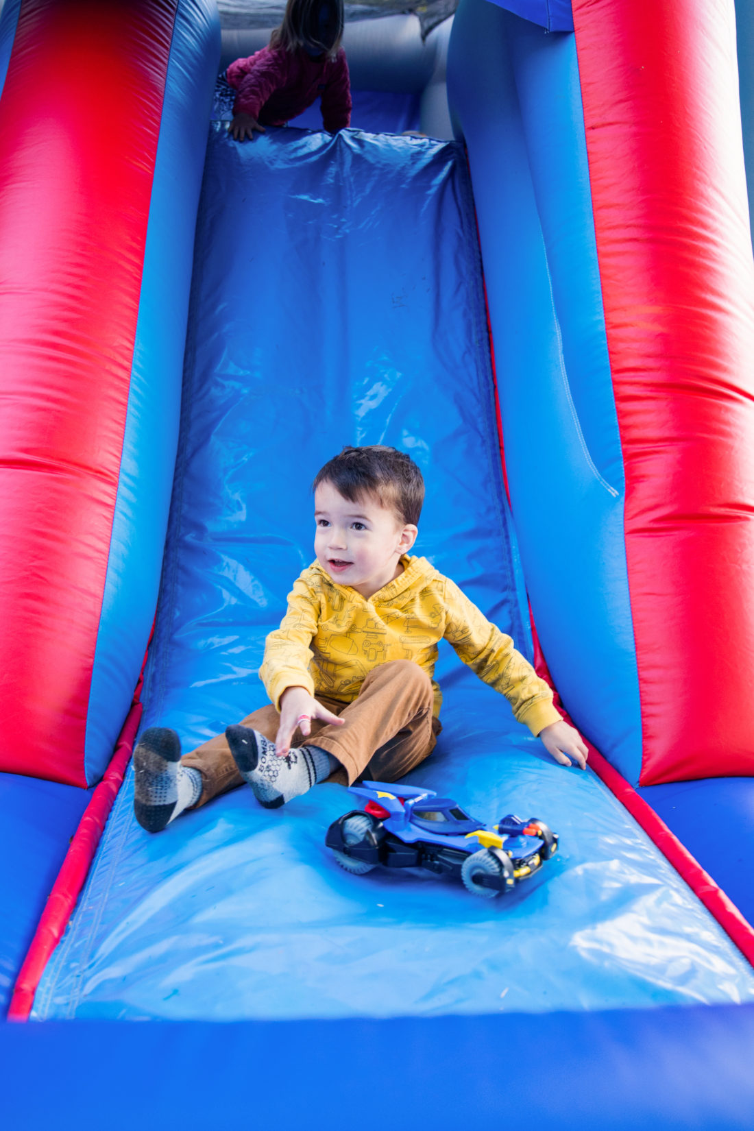 Major Martino slides down the side of the Bounce House at his Construction Zone themed birthday party